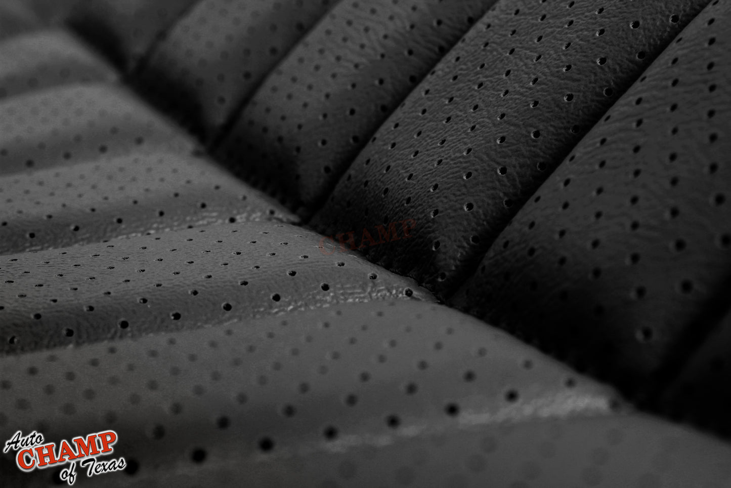 Close-up view of perforated black leather seat cover with detailed stitching, showcasing premium material.